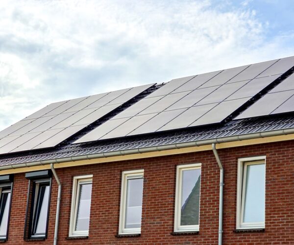 Newly build houses with solar panels attached on the roof against a sunny sky Residential Solar PV System